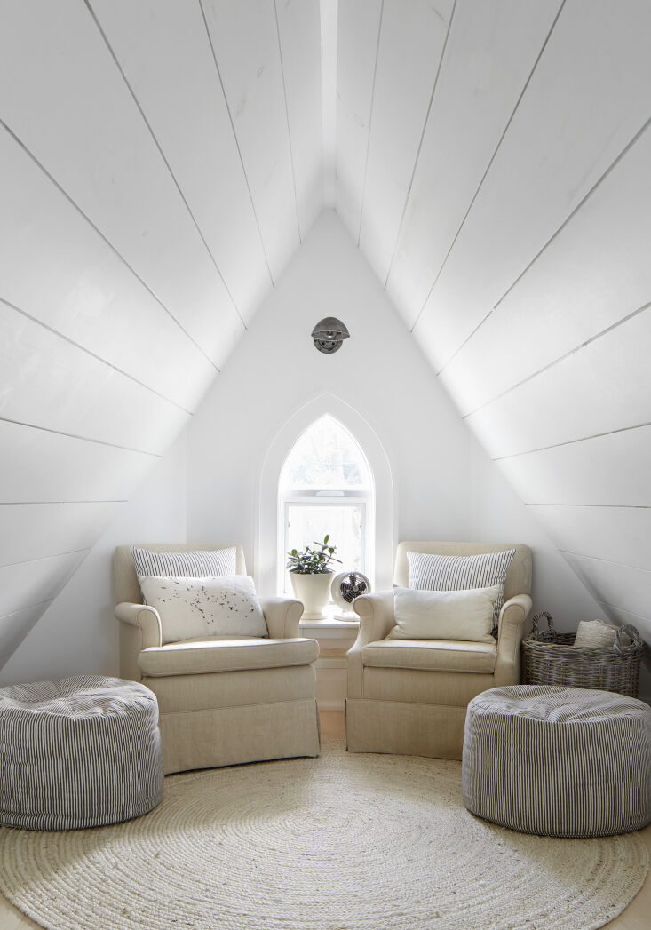 Armchairs with striped poufs and personal decorative objects.