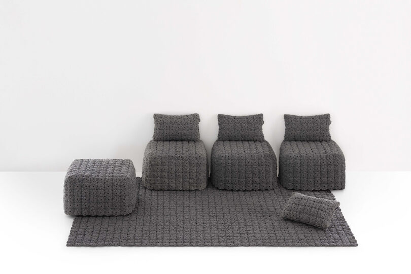 A comprehensive set of gray crochet-textured modular chairs, poufs, and rugs against a white background.