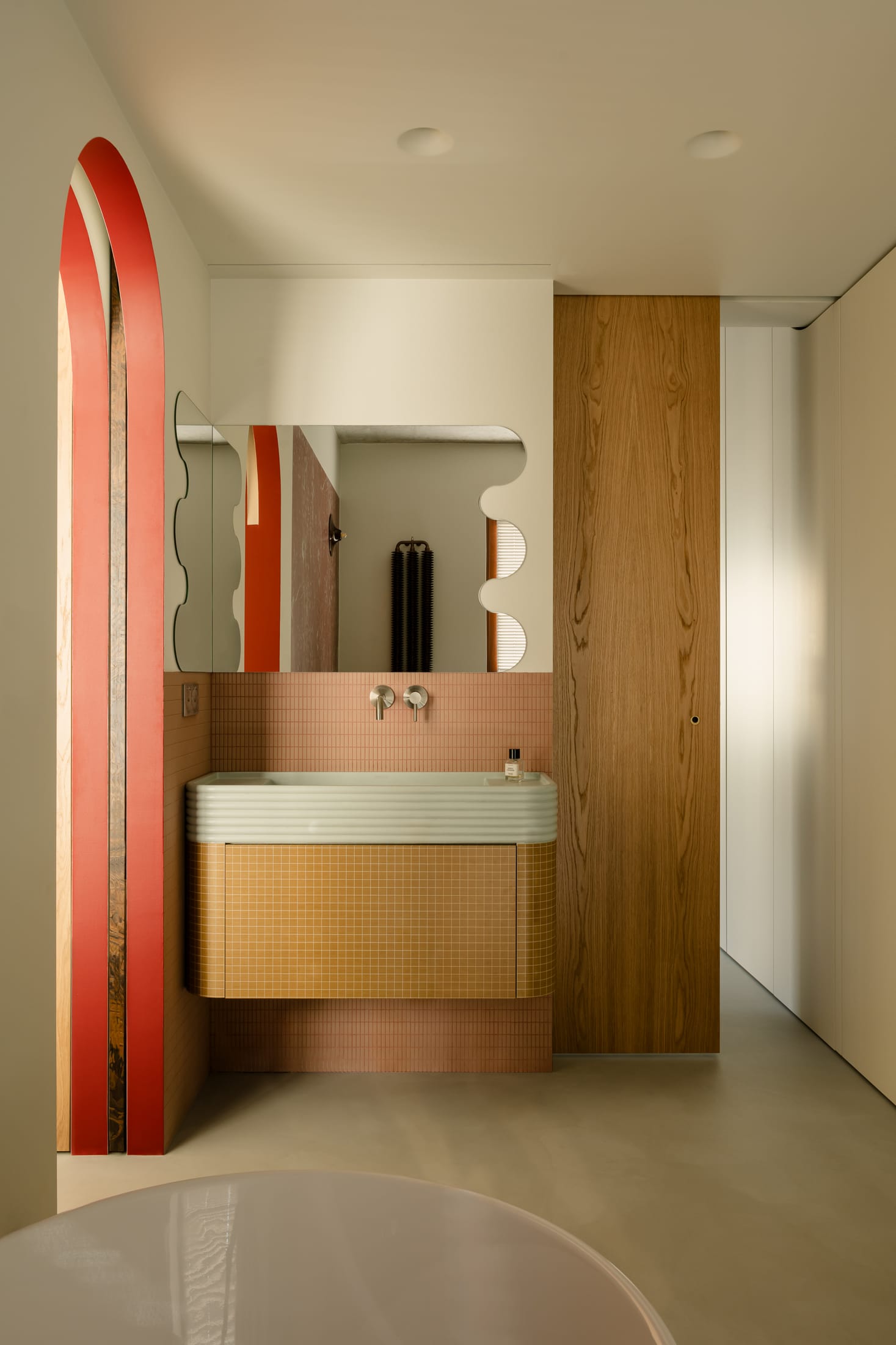 Bathroom interior featuring deep red Rosso Francia tiles and soft pink mosaics.