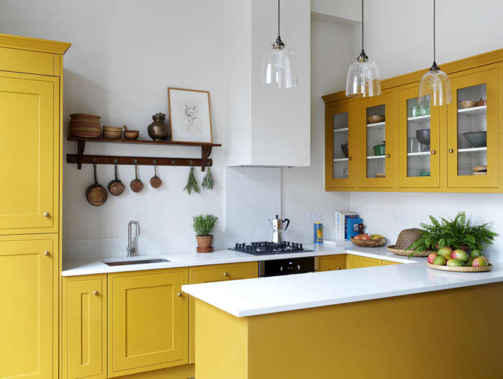 Close-up of traditional Shaker cabinets in a deep, vibrant yellow finish.