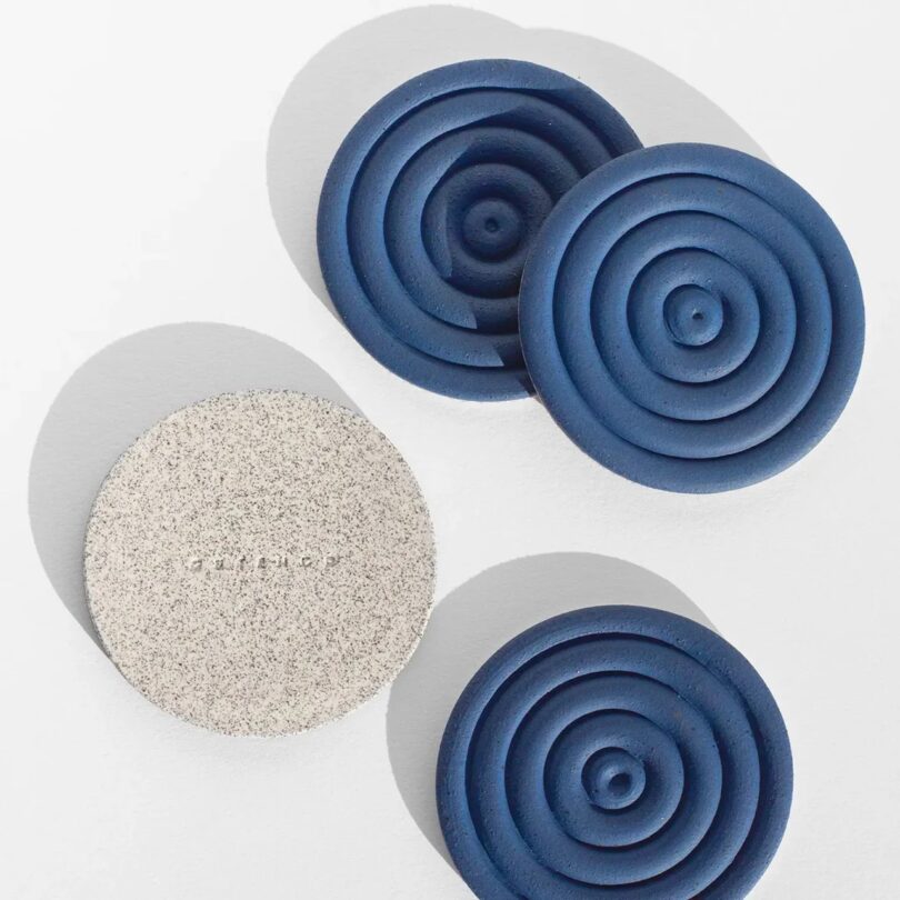 Blue spiral-patterned ceramic coasters showing both the top design and the speckled bottom.