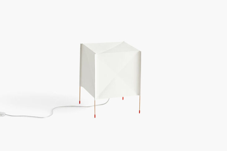 A square white paper cube table lamp emitting a soft glow.