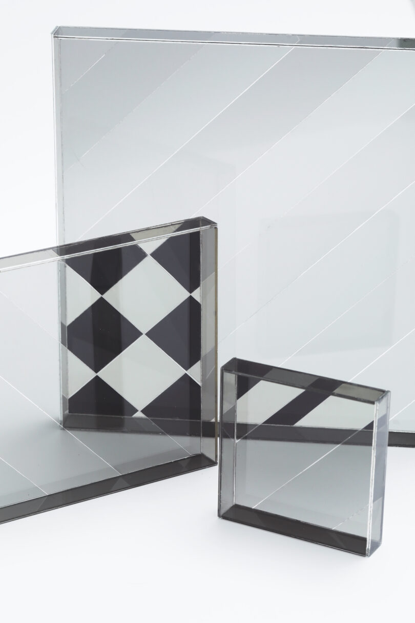 Three rectangular glass blocks with diagonal lines and geometric patterns arranged on a white background.