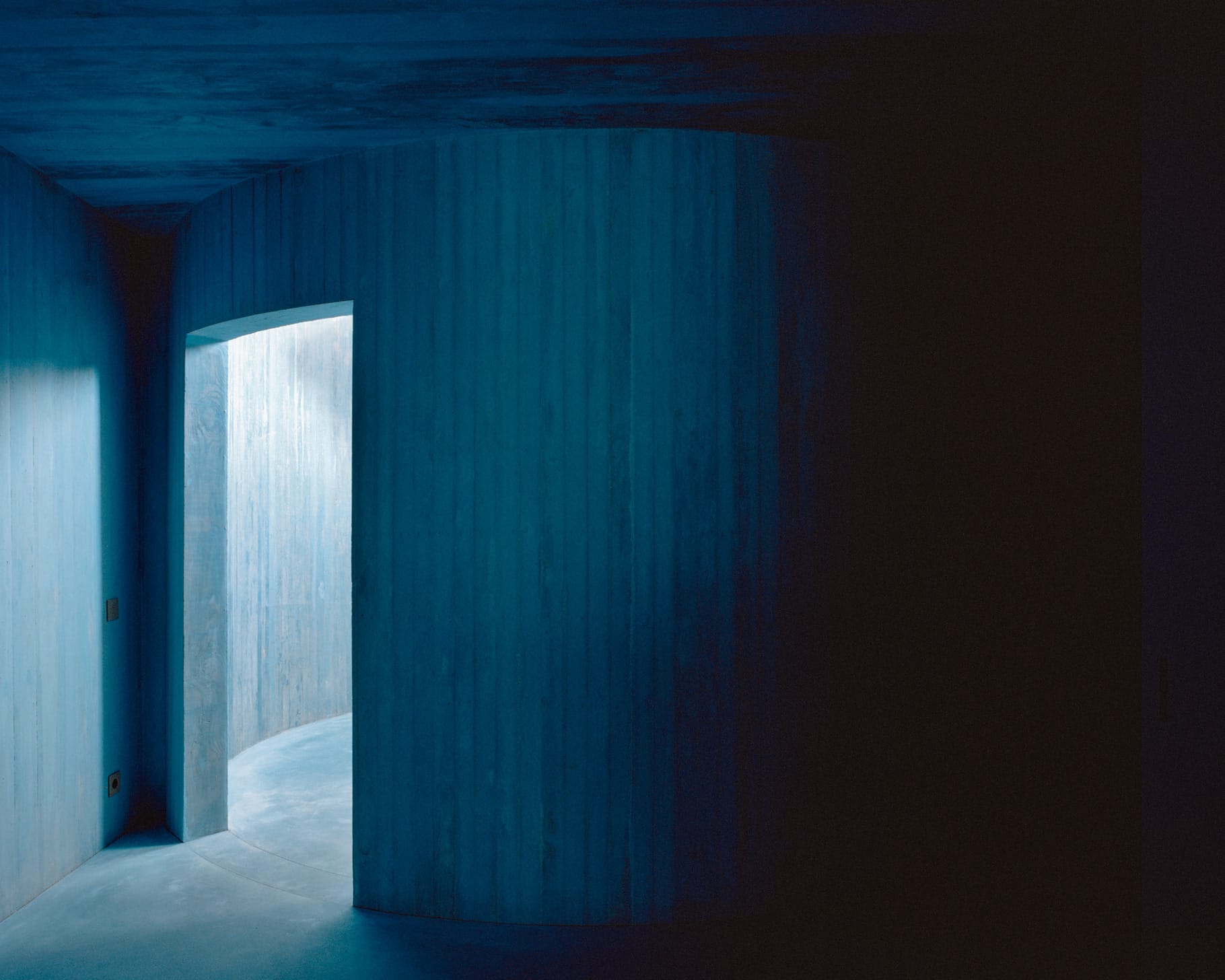 The top level of House II with high ceilings and natural light hitting the blue surfaces.