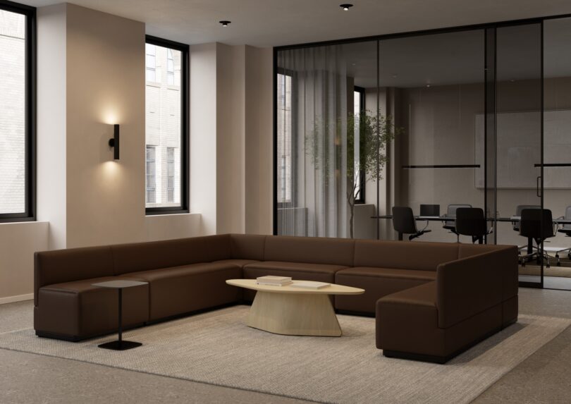 A U-shaped brown modular sofa system in a modern office waiting area.