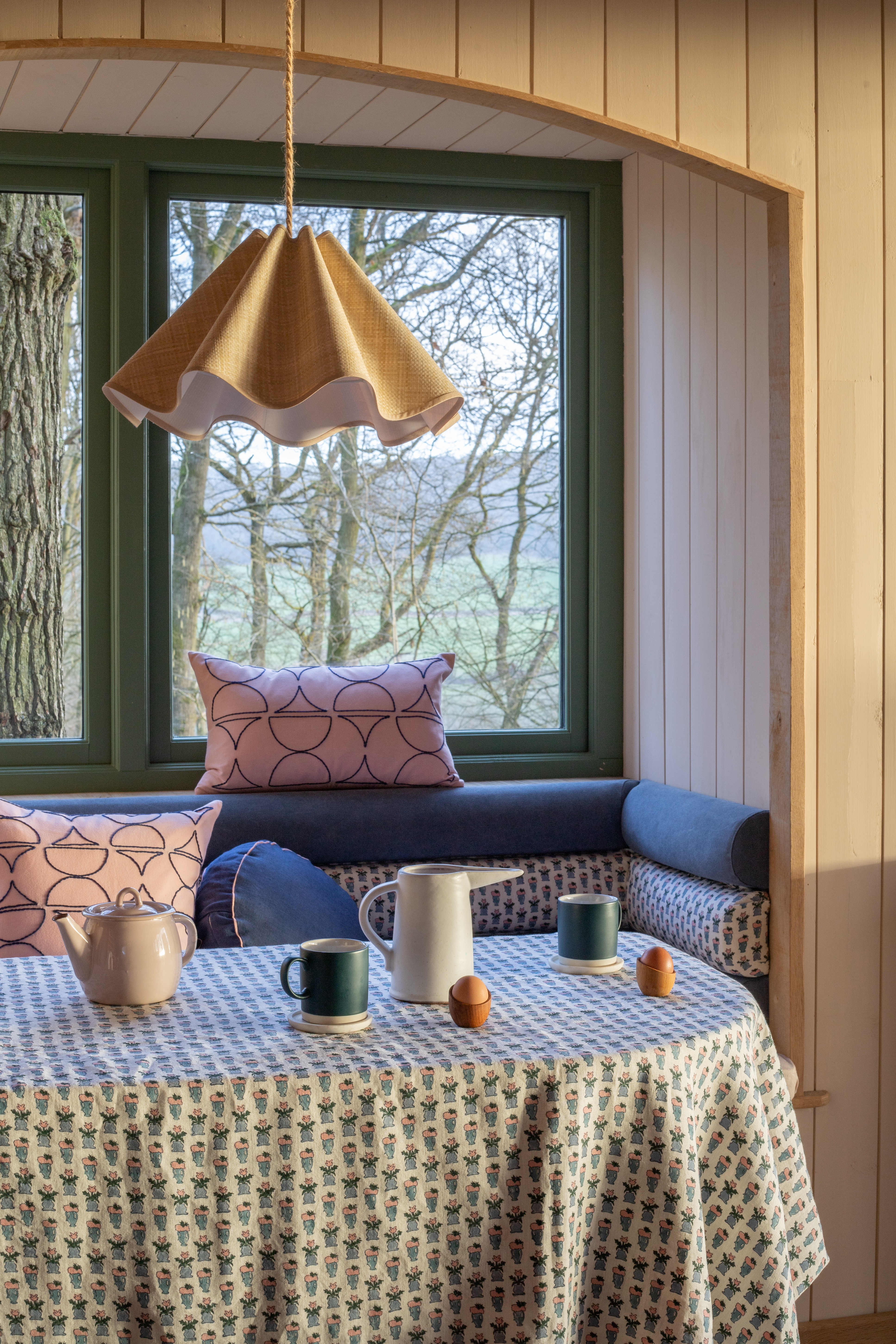 Woven paper wavy lampshade in a luxury treehouse hotel dining area.