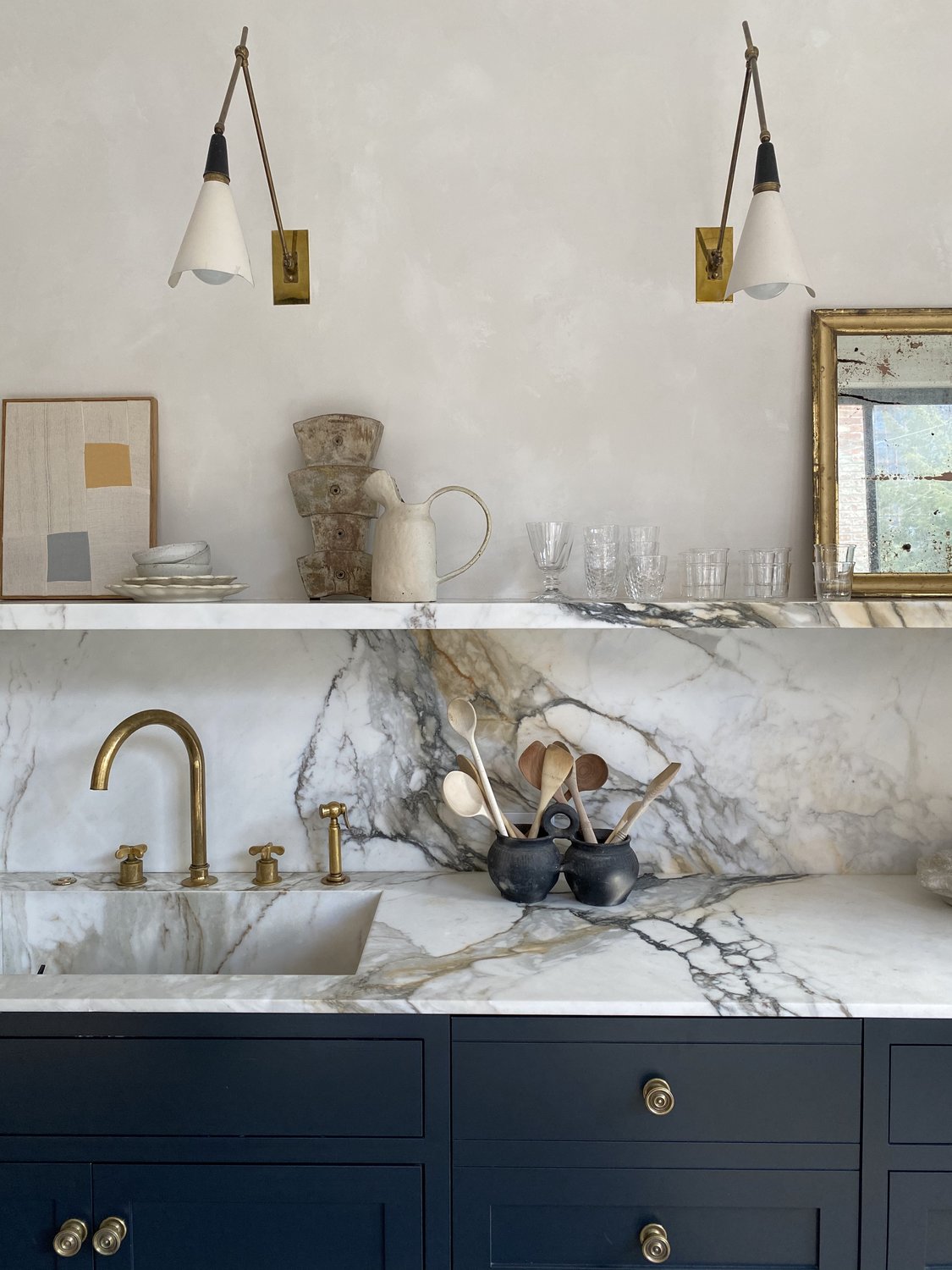 A wooden board featuring a raw sugar pumpkin, Yukon Gold potatoes, and fresh herbs.