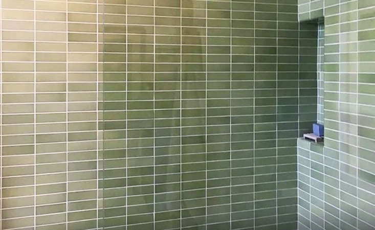 Close-up of matte-glazed ceramic field tiles in a warm, neutral earth tone.
