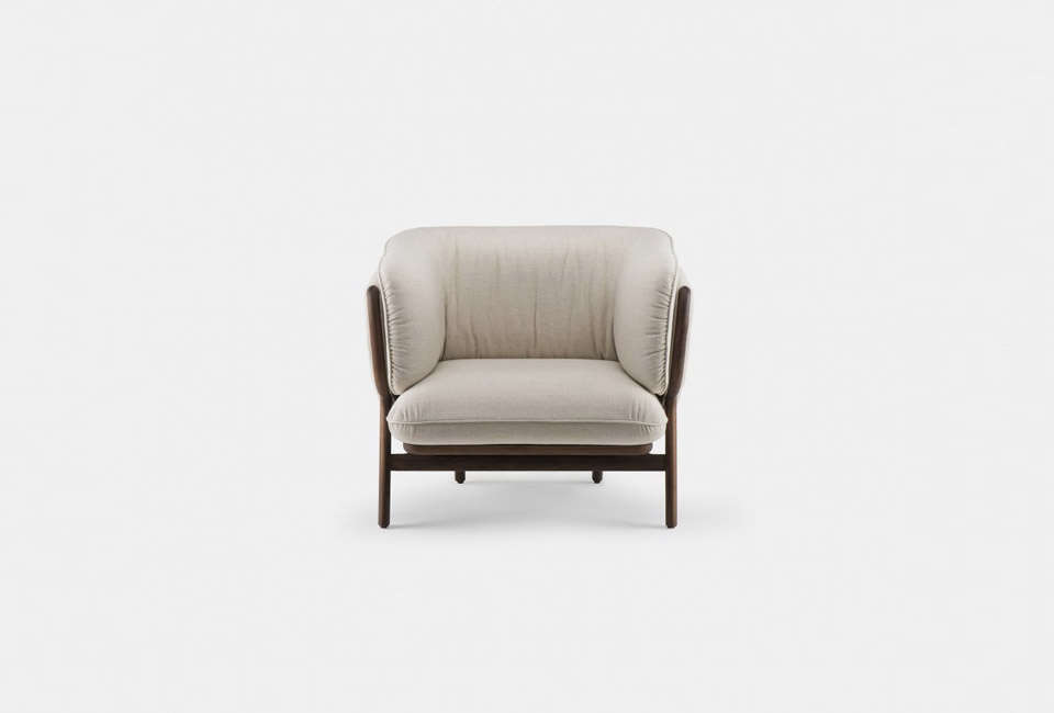 A minimalist Nichetto Stanley Armchair with wooden frame and soft upholstery.