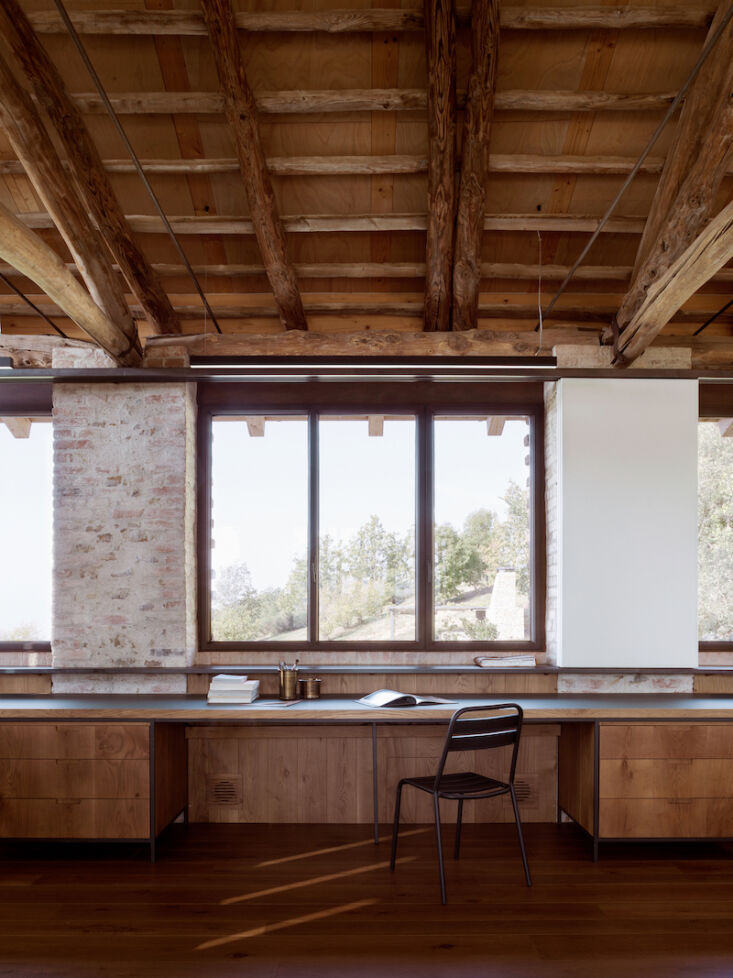 The interior of the hayloft studio featuring a chestnut timber roof structure and gable-end windows