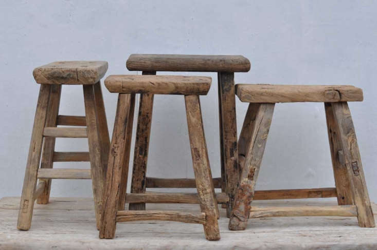 A pair of rustic antique wooden stools with weathered texture and traditional construction.