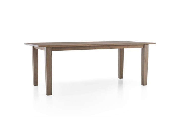 A rustic farm table made of salvaged barn wood in a dining room setting.