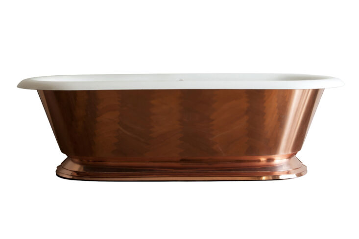 A polished copper cast iron bathtub, a centerpiece for high-end boutique bathroom design.