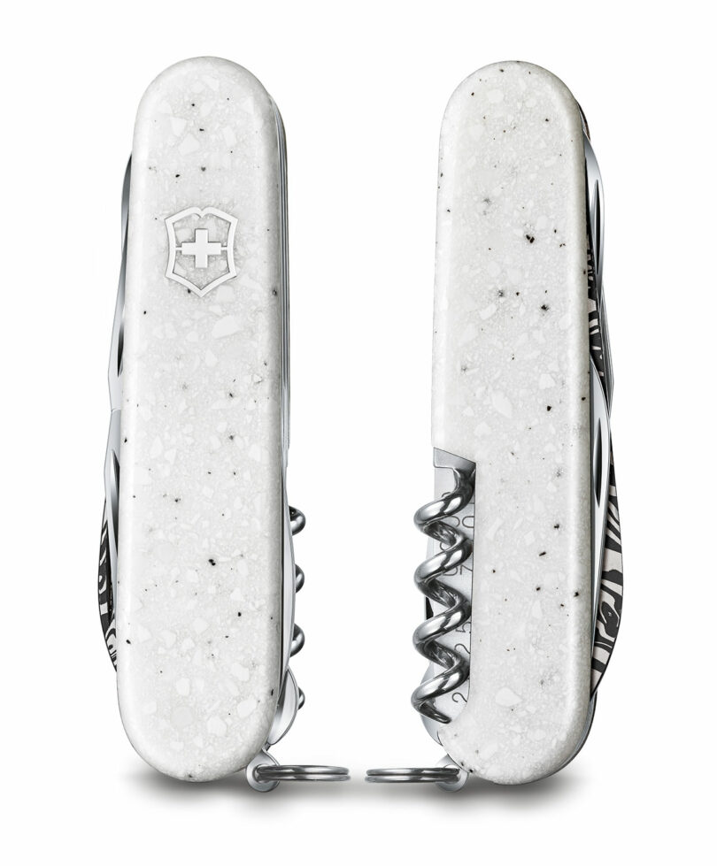 Two closed white Victorinox knives with speckled Corian handles showing unique grain patterns.