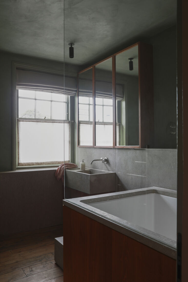Green tadelakt bathroom with limestone and sapele wood accents.