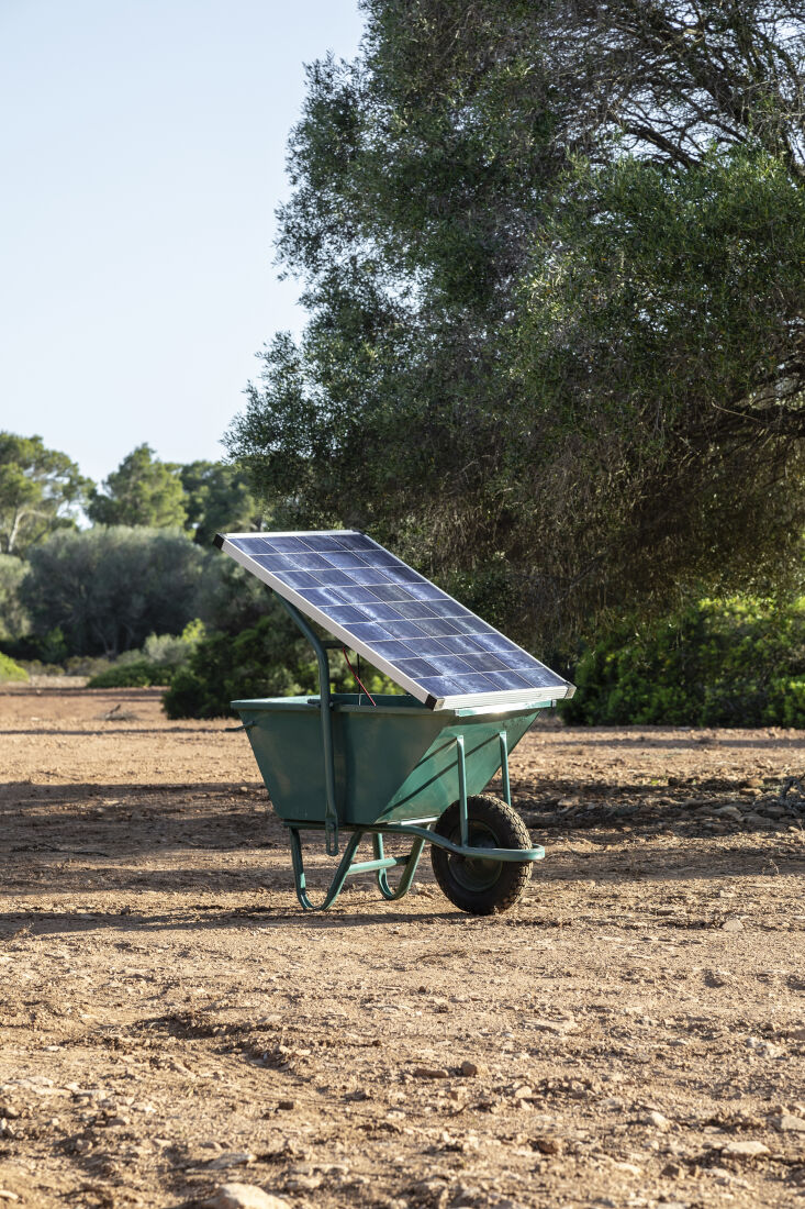 A yellow wheelbarrow fitted with a solar panel, known as the Solar Roller.