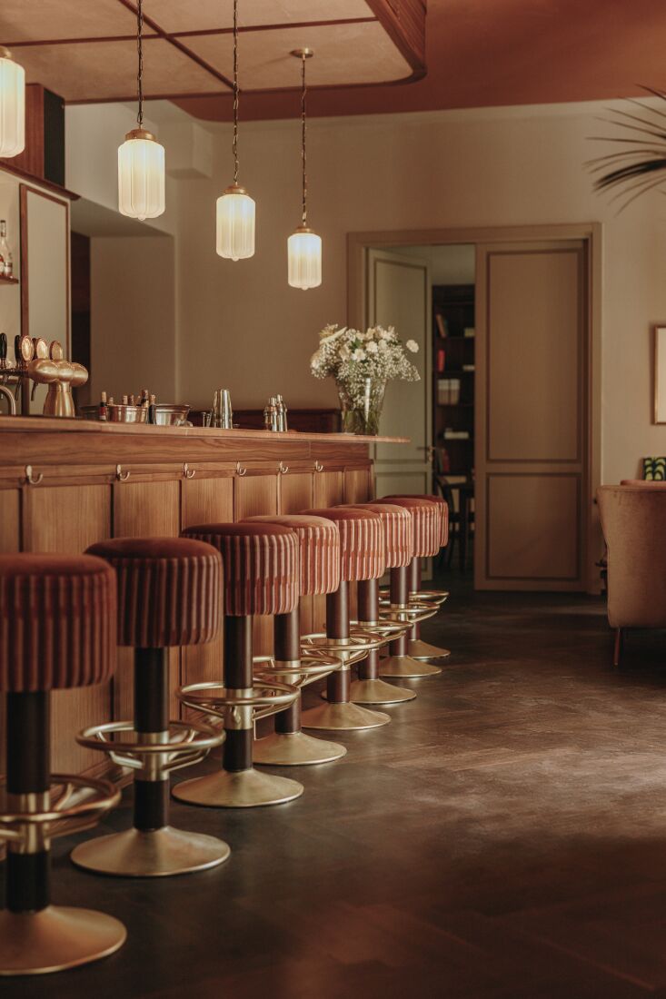 Hotel bar with warm lighting and midcentury modern furniture.