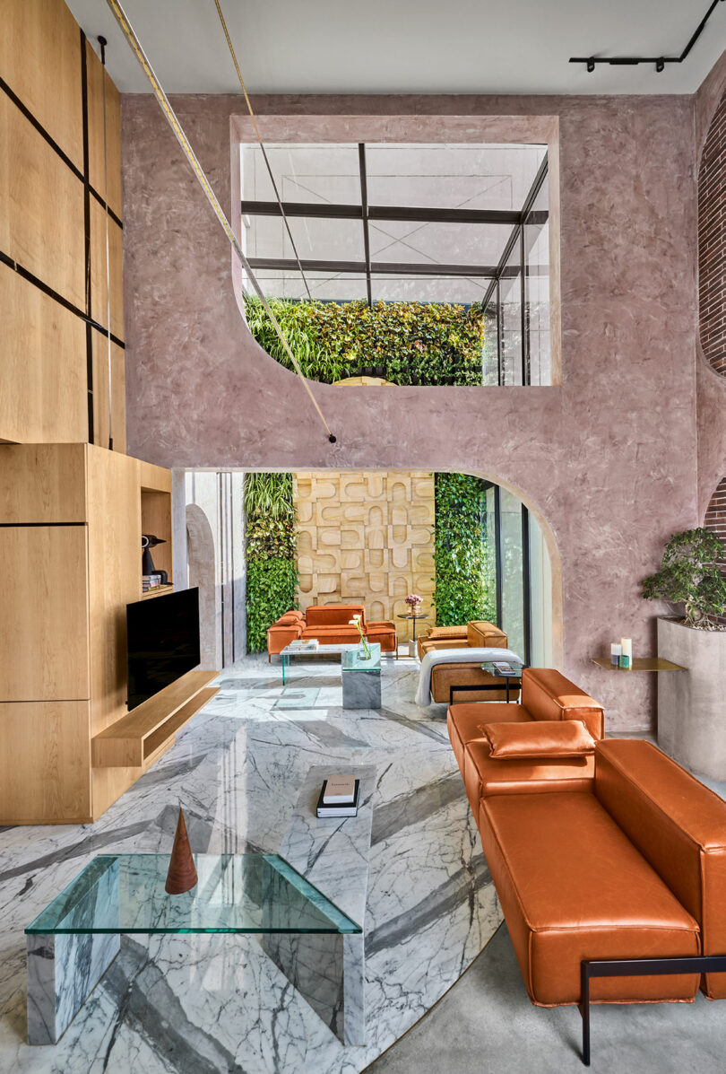Modern living room featuring a large vertical garden wall next to floor-to-ceiling windows.