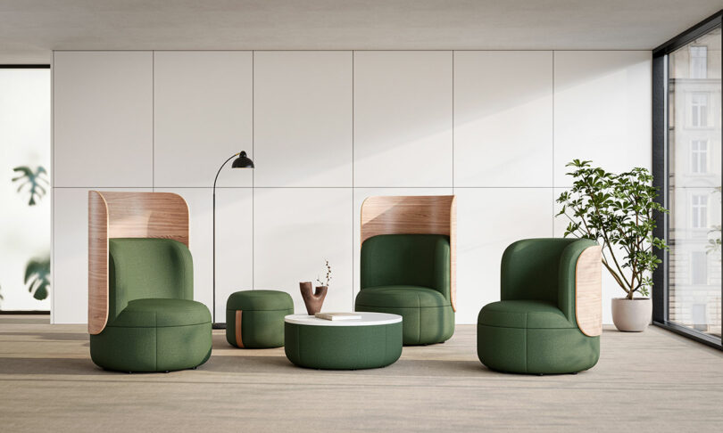 A green Dotti lounge chair paired with a round white coffee table in a modern office setting.