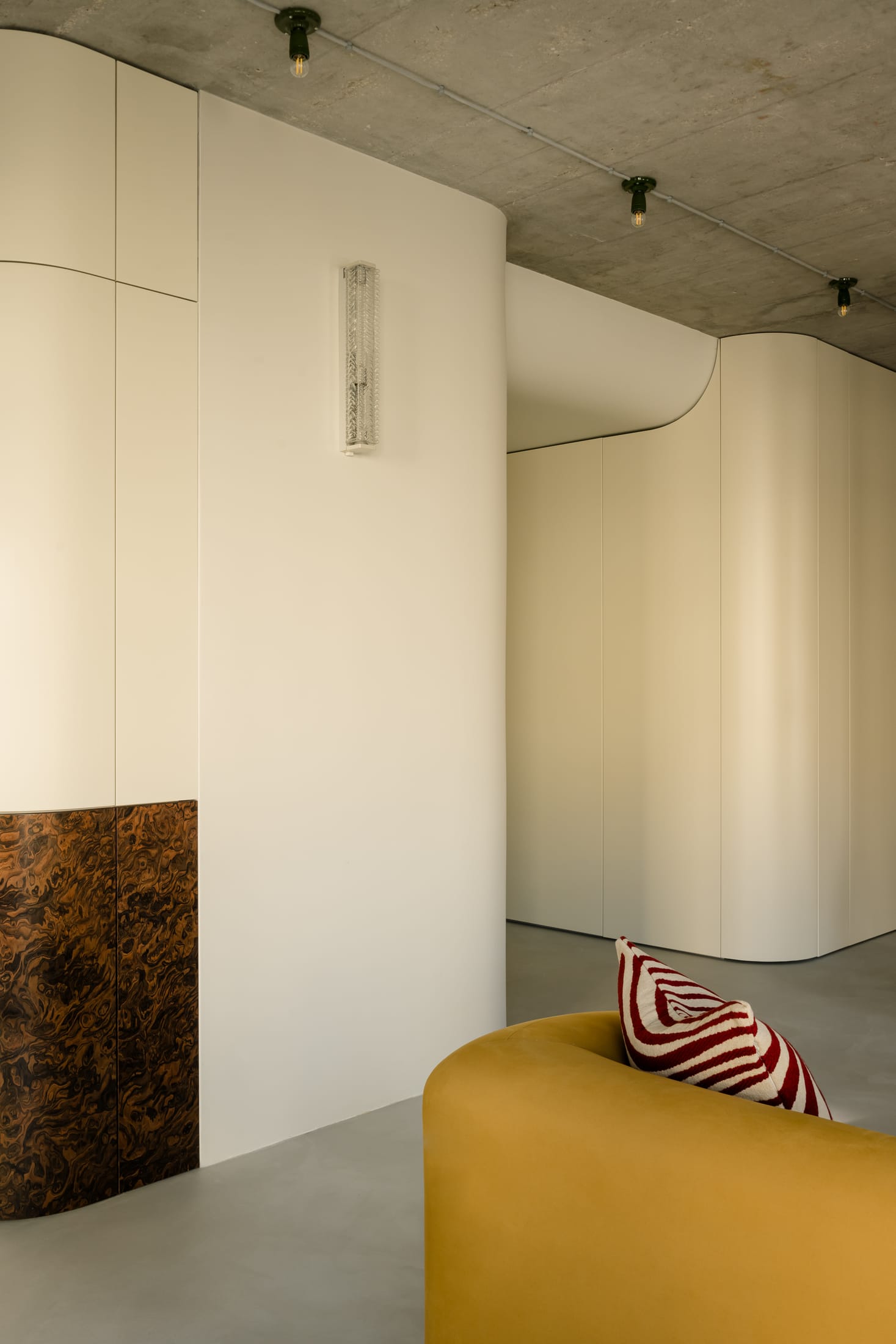 Burgundy Verner Panton dining chairs set against a backdrop of raw concrete and wood.
