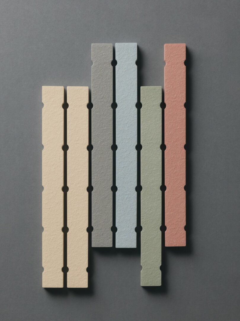 Five vertical textured tiles in beige, pale yellow, light blue, green, and red arranged side by side.