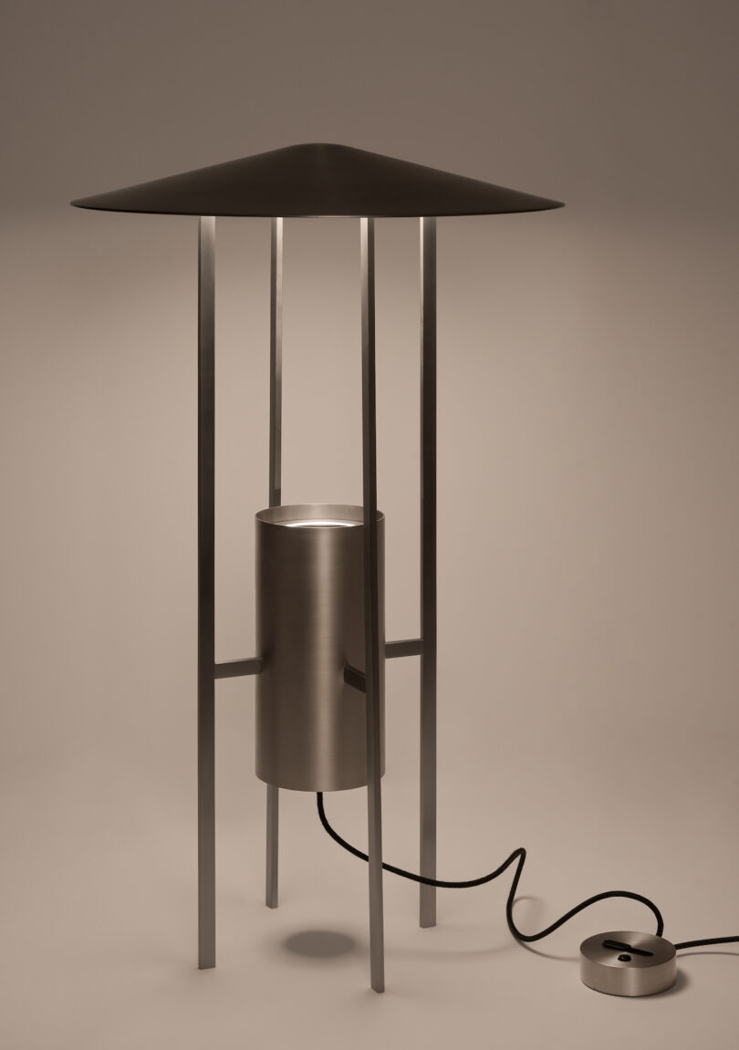 A detailed studio shot of the 1953 metal floor lamp showing its wide conical shade and four-legged base.
