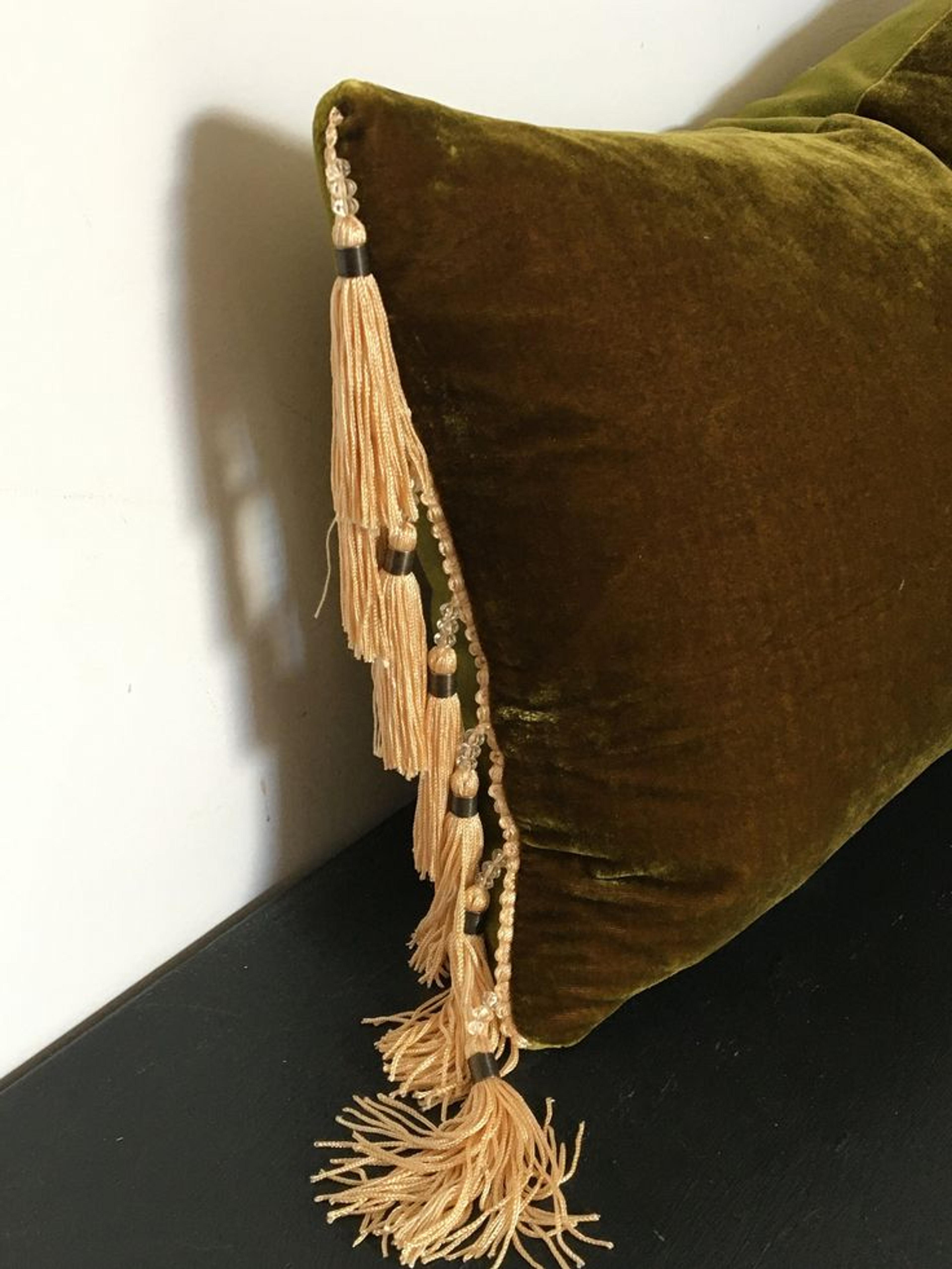 Detail of a soft fabric pillow featuring a decorative tassel.
