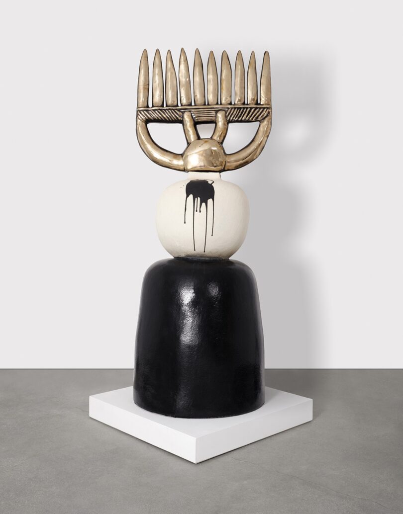 Minimalist sculptural art pieces featuring bronze and monochrome elements on a plinth.