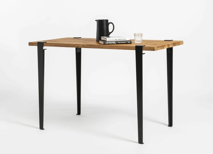 Modern desk with a textured reclaimed wood top and sleek black metal legs.