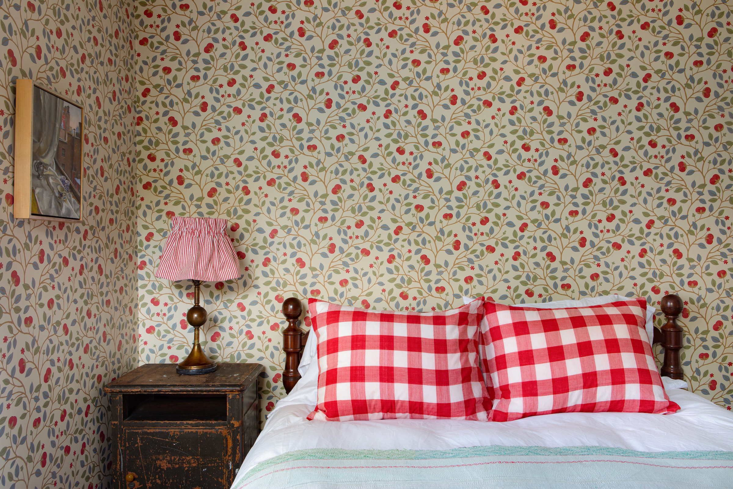 Close-up of traditional red-and-white gingham pillows against a vintage floral backdrop.