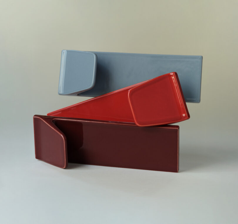 A geometric composition of overlapping red, maroon, and gray ceramic tiles.