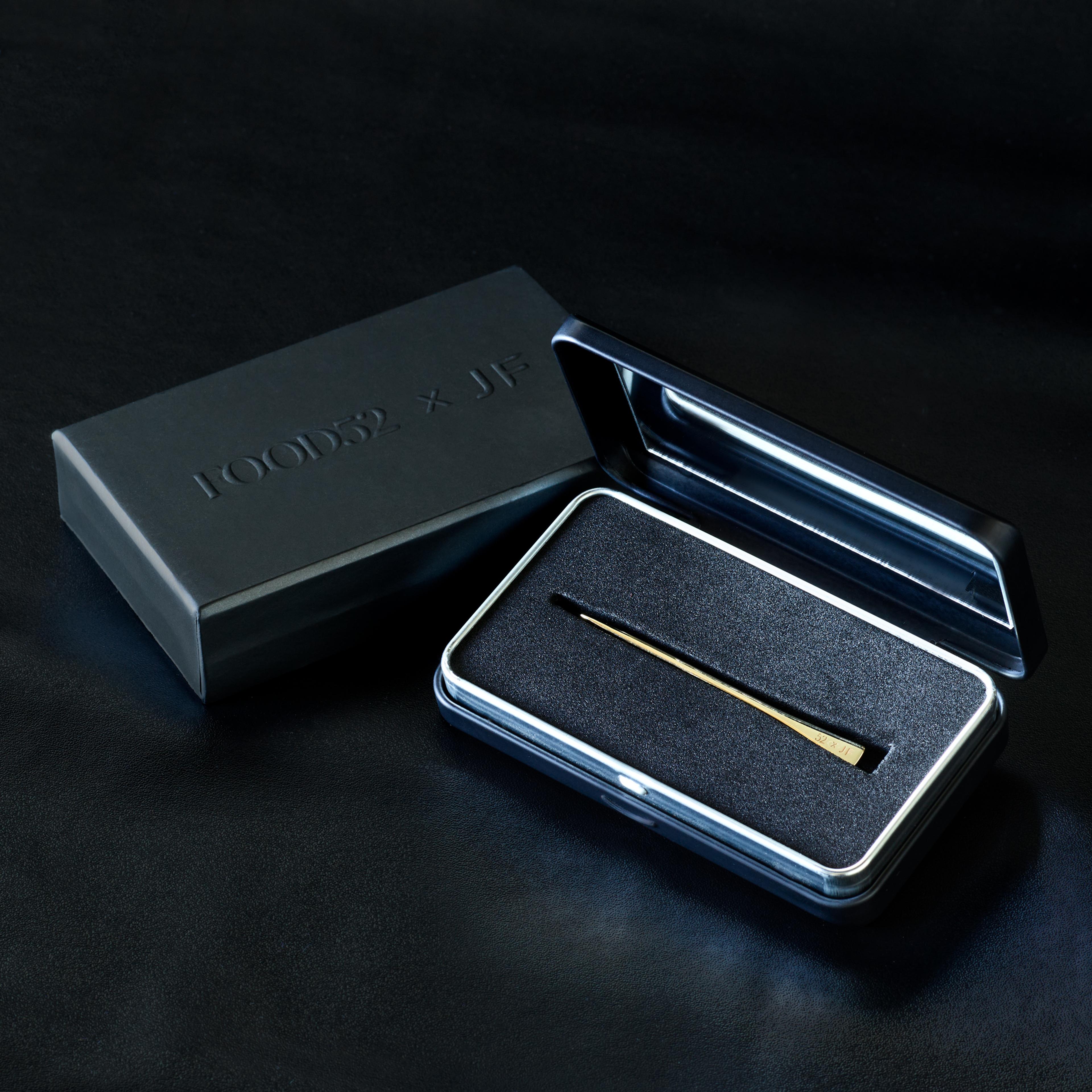 A 14k gold toothpick tucked into a sleek carrying case with a built-in mirror.