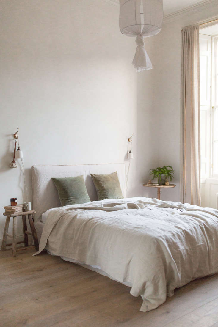 Close-up detail of a bedroom wall with warm neutral limewash paint showing subtle texture.