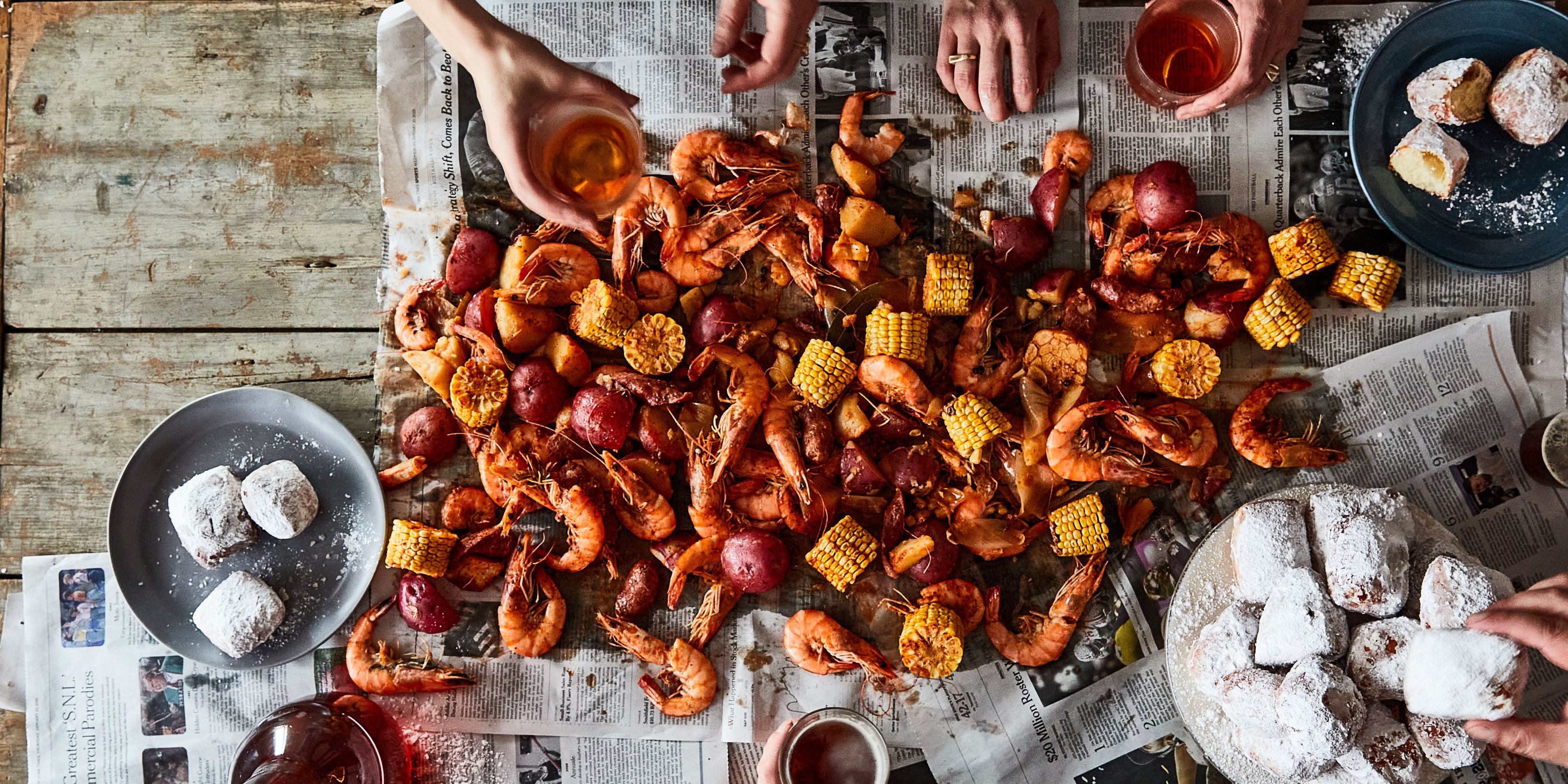 A person organizing cleaning supplies next to a table with party leftovers and sports decorations.