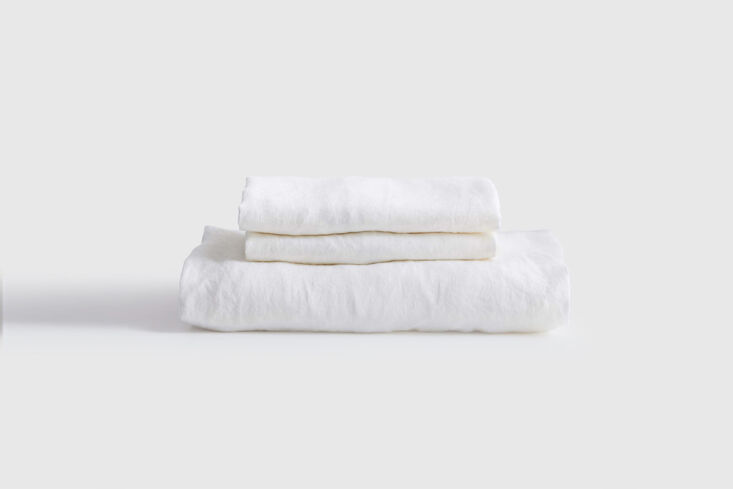 Crisp white European linen sheets layered on a bed.