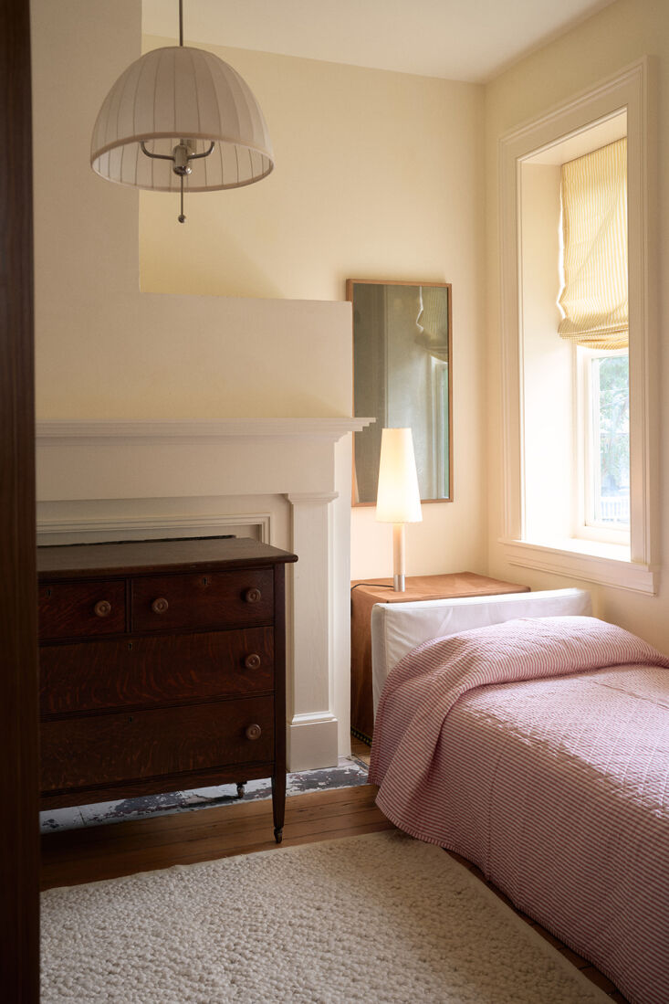 A bedside table featuring a Básica lamp in a classic, light-filled bedroom.