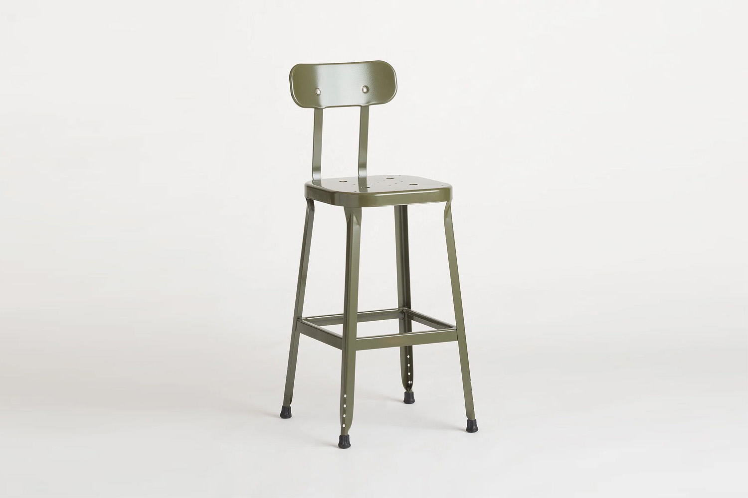 A green utility stool with a minimalist metal frame standing against a neutral background.