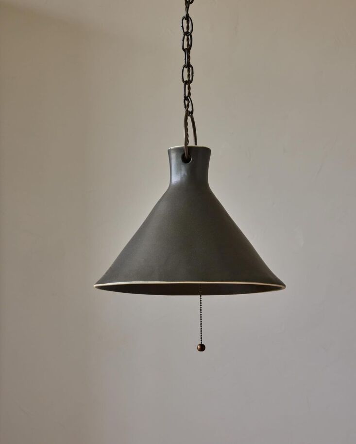 A semi-matte black Pepper ceramic pendant light with unglazed stoneware rims.