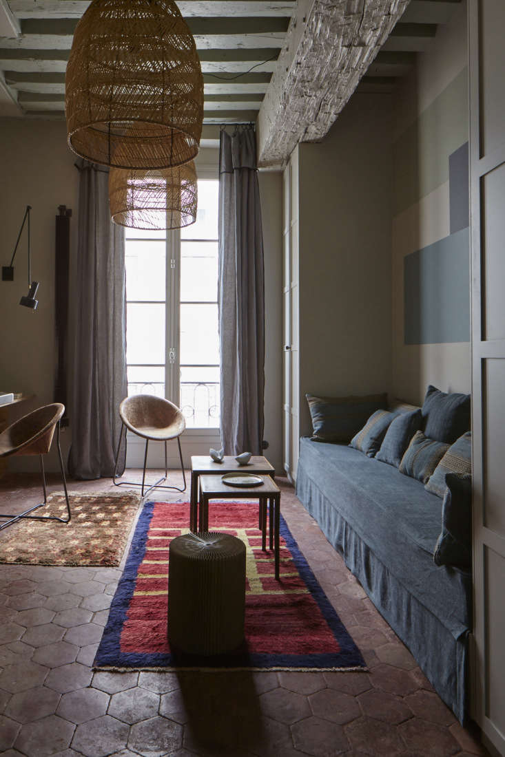 Hexagonal terracotta floor tiles topped with colorful vintage rugs.