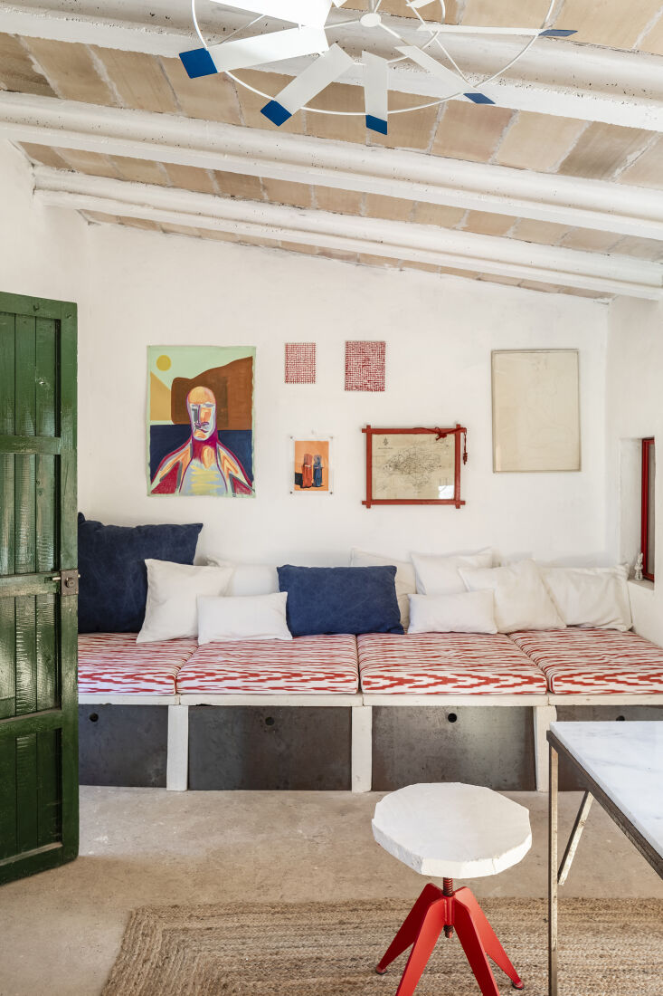 A daybed made from sandstone slabs with local fabric cushions and integrated metal storage.