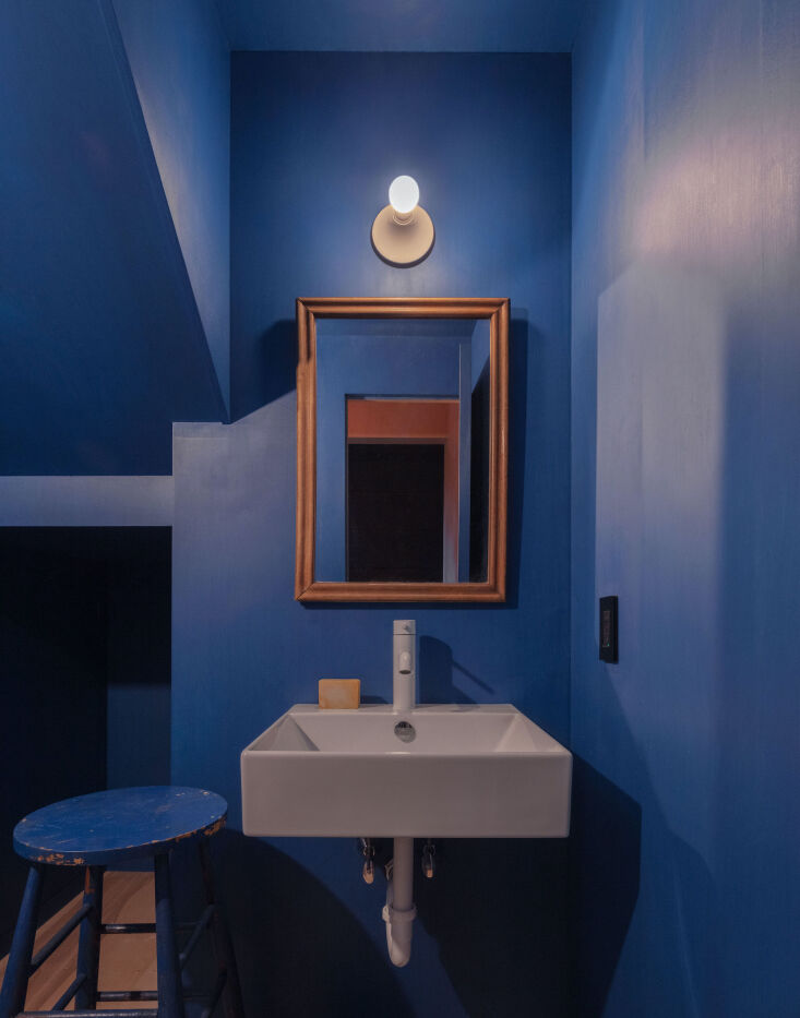 Powder room with semi-sheer Yves Klein blue stained plywood walls.