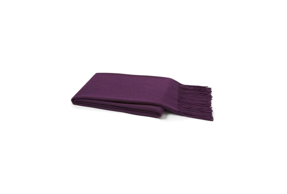 A deep purple solid cashmere throw blanket folded neatly.