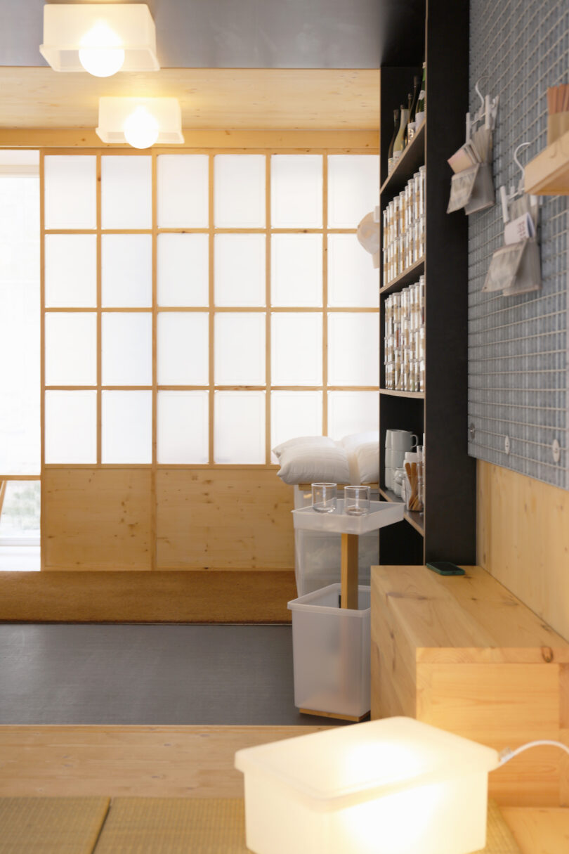 A minimalist room with warm wooden furniture, soft lighting, and muted taupe walls.