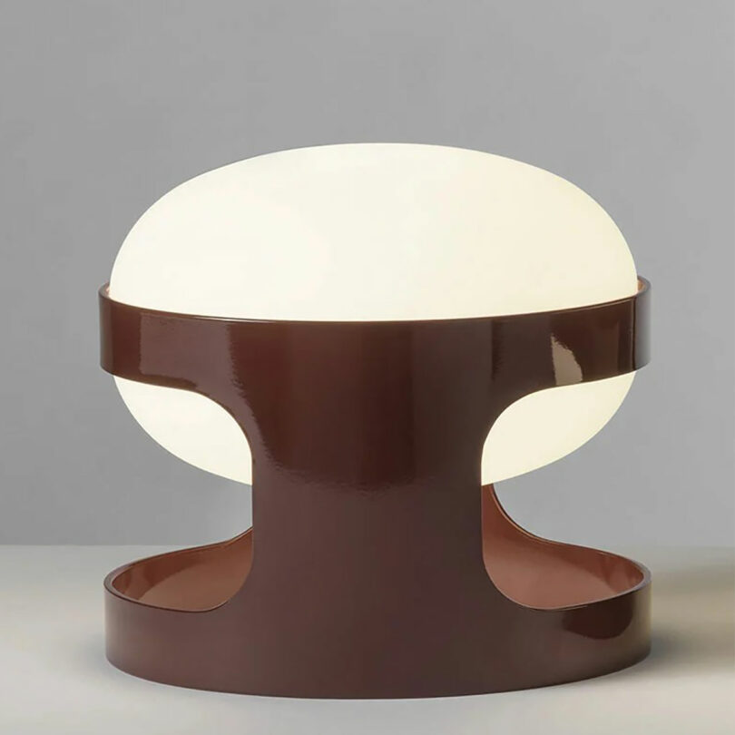 A classic Joe Columbo table lamp with a brown base and white dome shade.