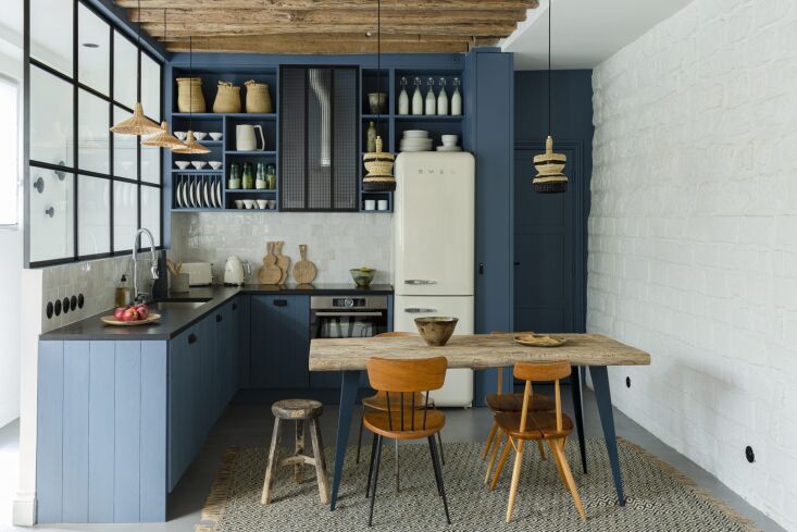 A steel-framed interior window between an entry hallway and a small kitchen.
