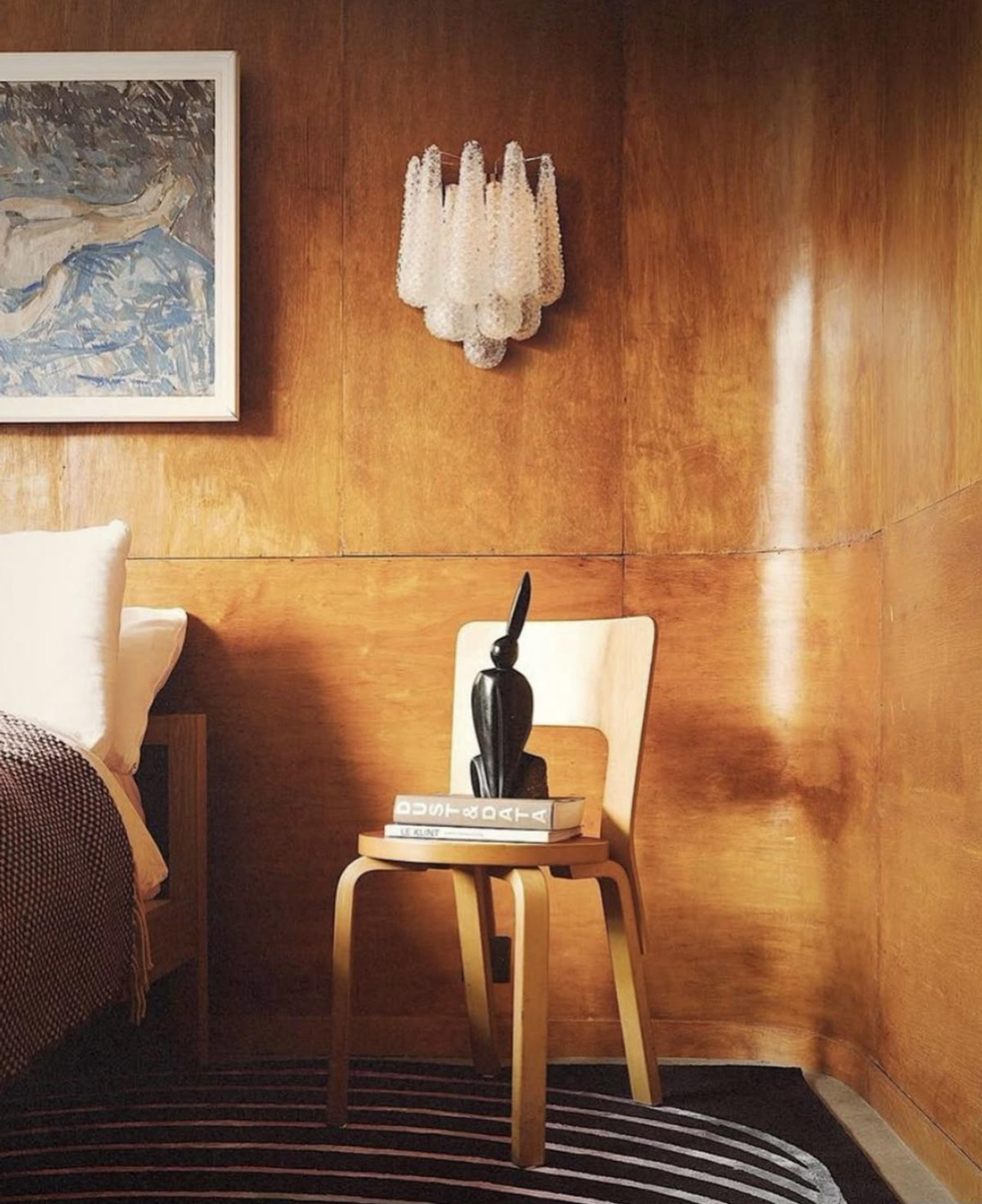 Dramatic lighting hitting a dark wood-paneled wall, creating long shadows.