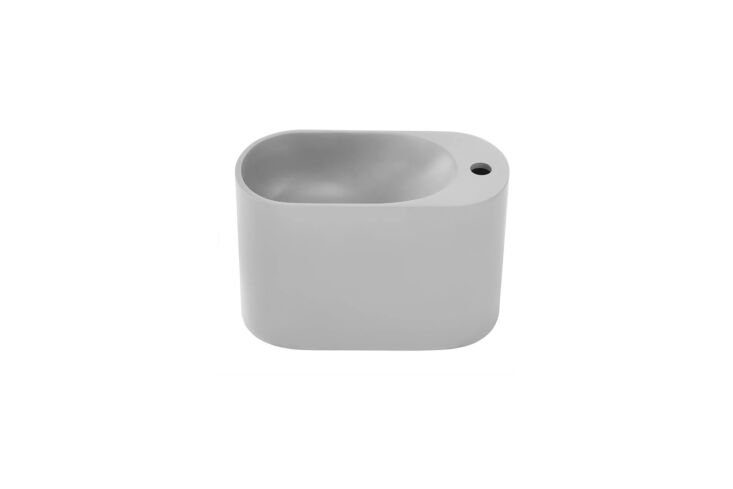 A circular stone composite wall-mounted sink with a soft gray finish.