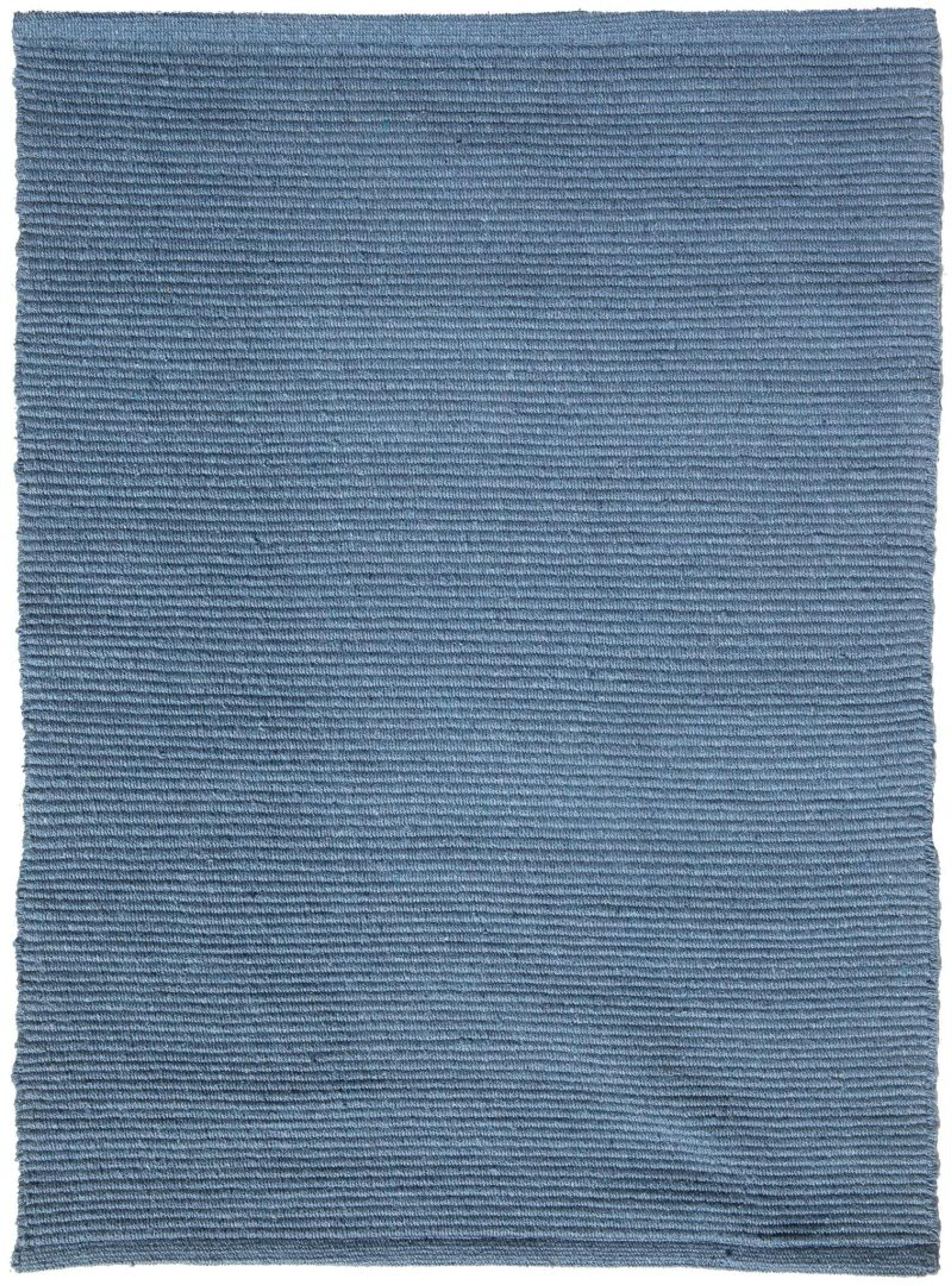 A blue denim flat-weave cotton rug showcasing a tight, snag-resistant texture.