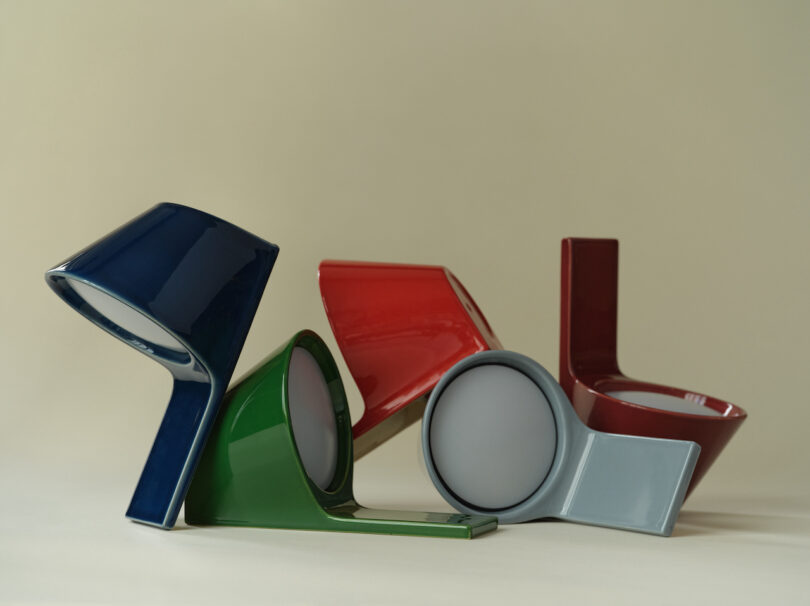 An array of four ceramic tile lamps in blue, green, red, and gray showing different angular profiles.