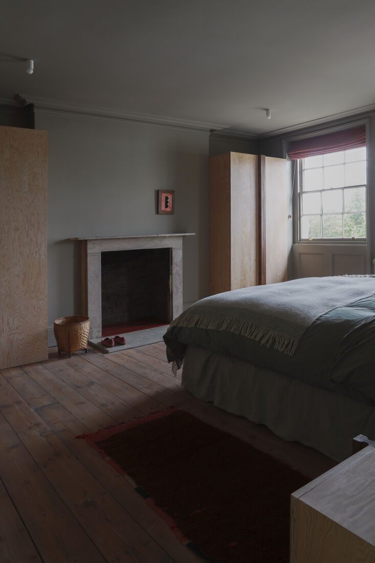 Minimalist master bedroom with Douglas fir cabinets and Farrow & Ball light gray walls.